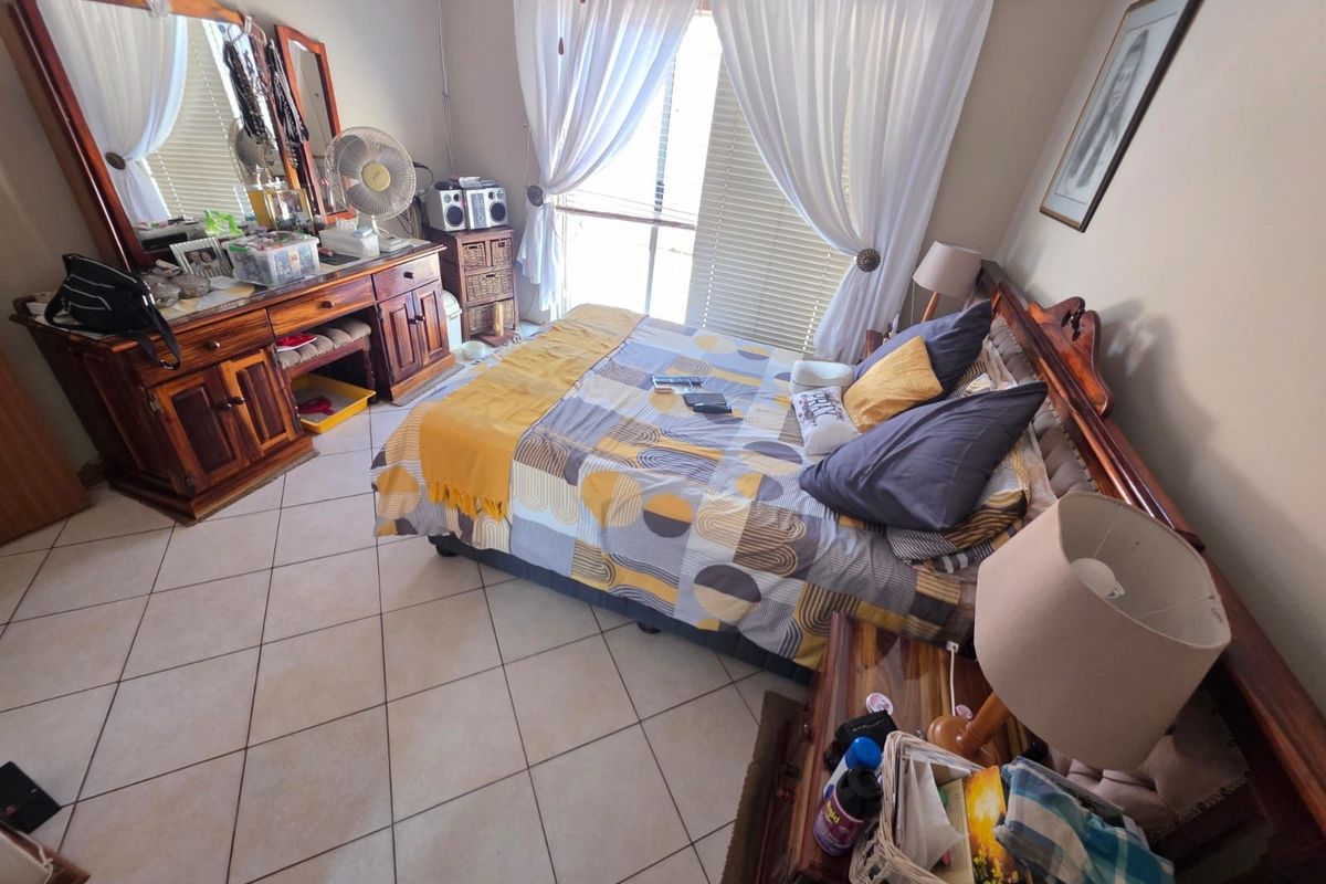 A bedroom featuring tiled flooring and sliding glass doors that provide access to the exterior.