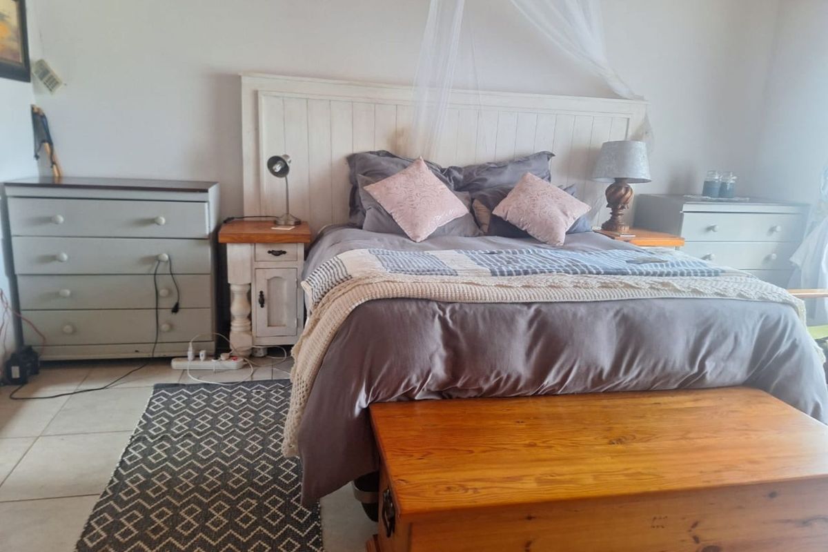 A bedroom featuring tiled flooring and a built-in headboard design.