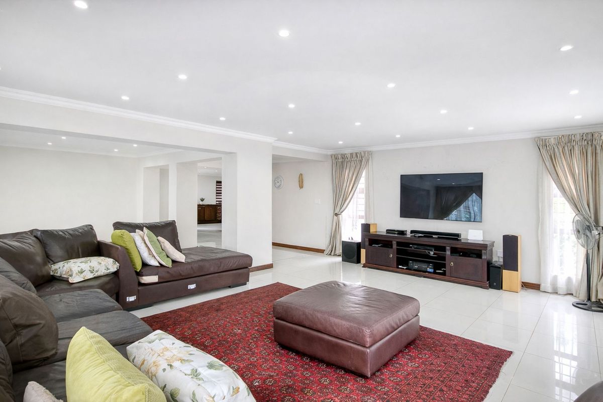 Spacious living room featuring polished tile flooring, recessed ceiling lighting, and a neutral color palette, creating a bright and open atmosphere.