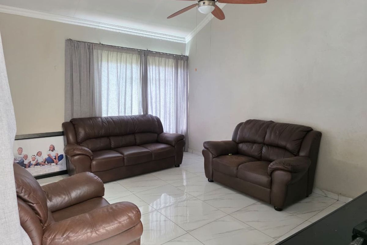 A living room featuring polished marble-look floor tiles, crown molding, and a ceiling fan.
