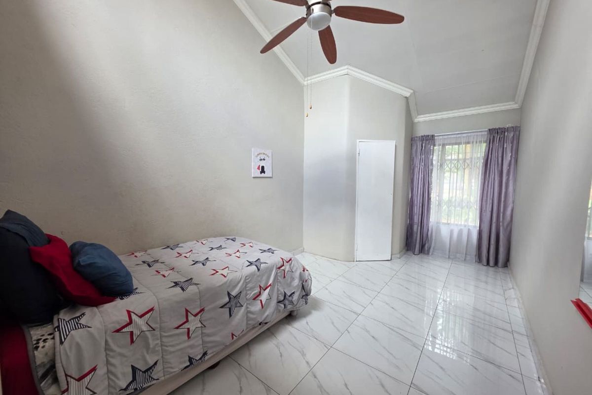 A bright bedroom featuring high vaulted ceilings, a ceiling fan, and modern white marble-look floor tiles.