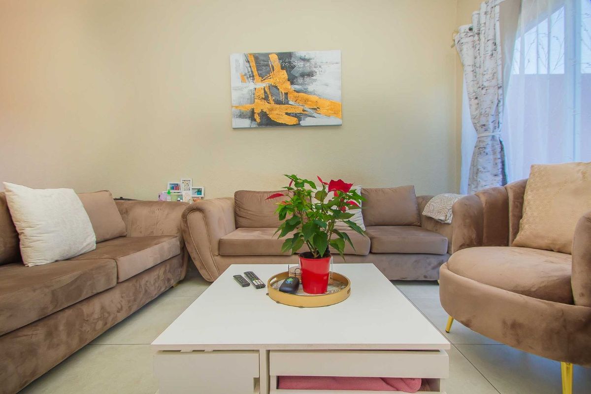A comfortable living room featuring neutral tiled flooring and a bright, open layout suitable for relaxation and family gatherings.