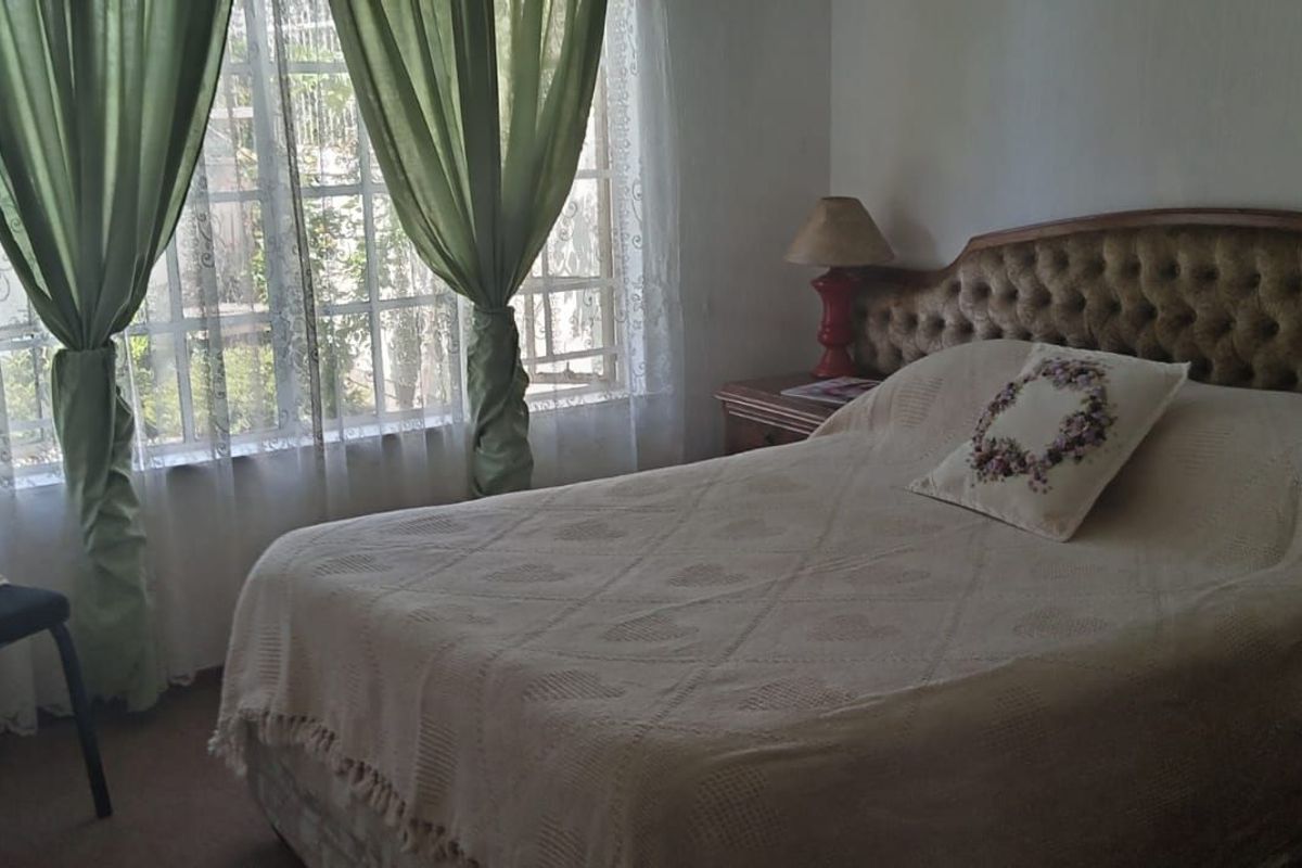 A bedroom featuring a window with security bars and a standard interior door.