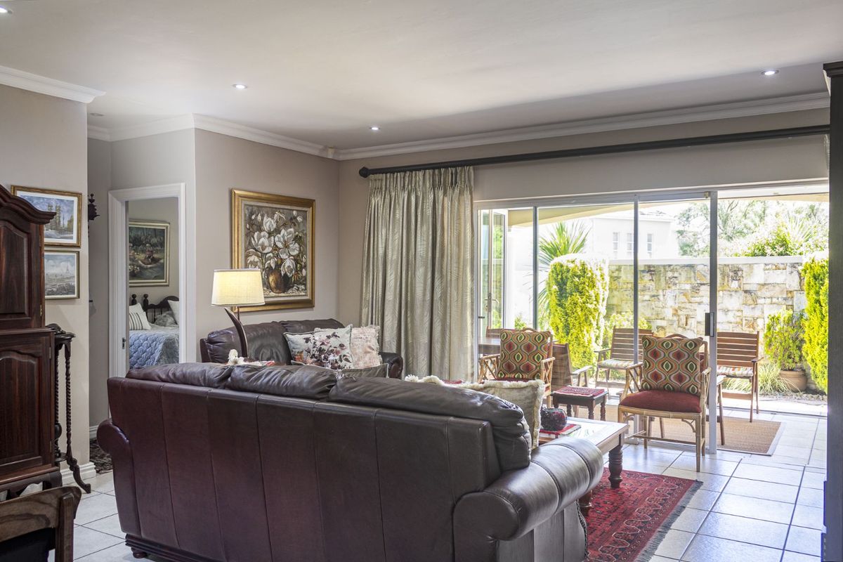 A comfortable living room featuring tiled flooring, recessed ceiling lighting, and large sliding glass doors that provide direct access to an outdoor patio area.