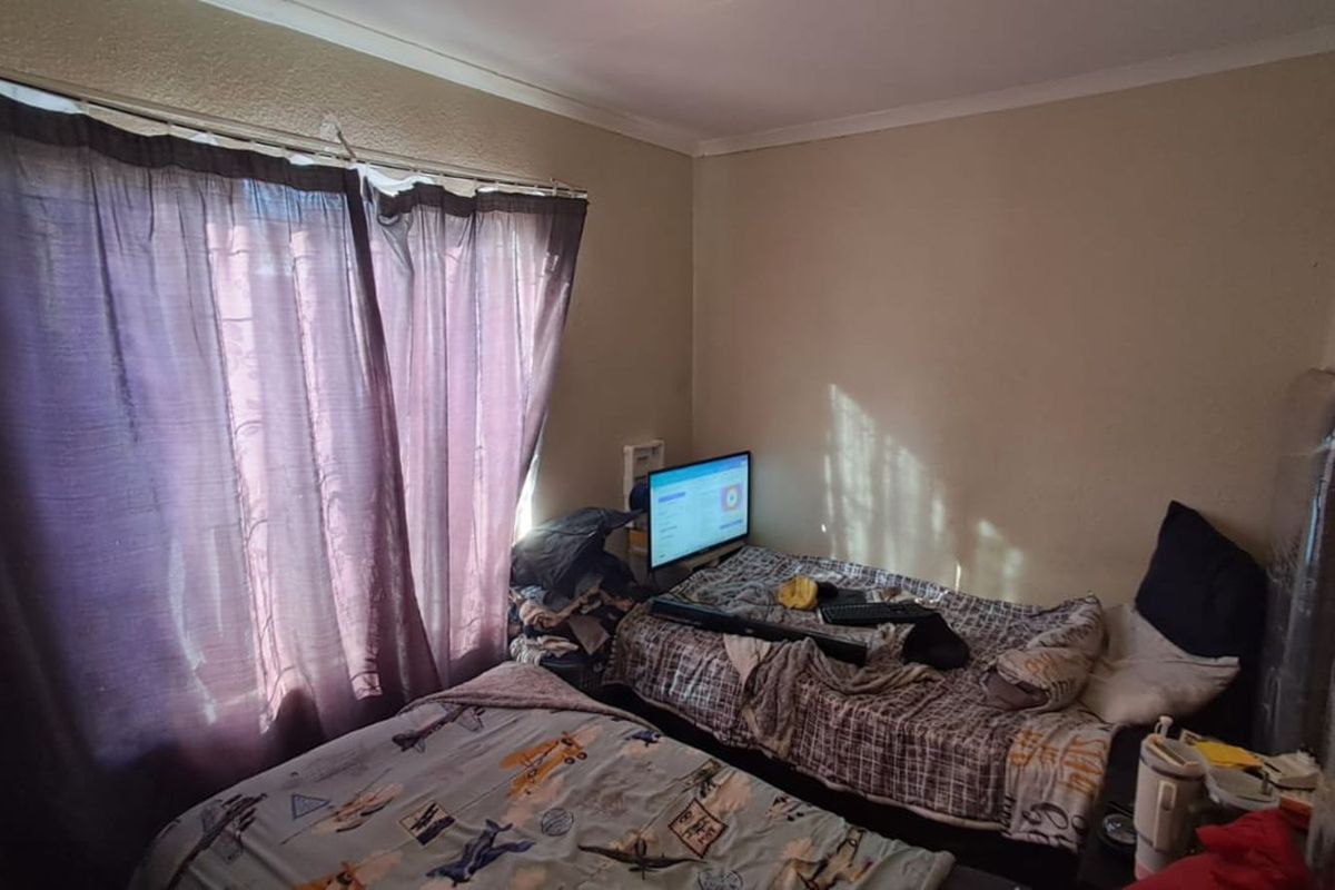A bedroom featuring a window with curtain tracks and standard ceiling cornicing.