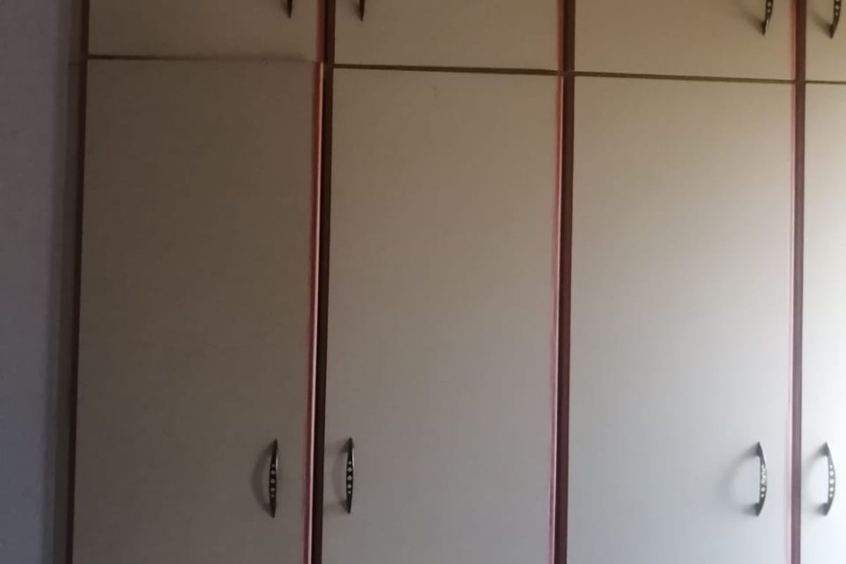 Built-in bedroom cupboards featuring floor-to-ceiling storage with multiple doors and integrated handles.