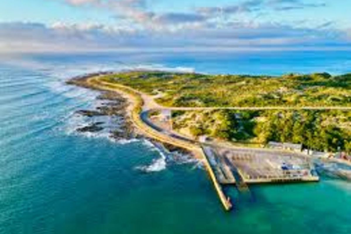Aerial view of the coastal property location, showcasing the surrounding shoreline, ocean, and local infrastructure.