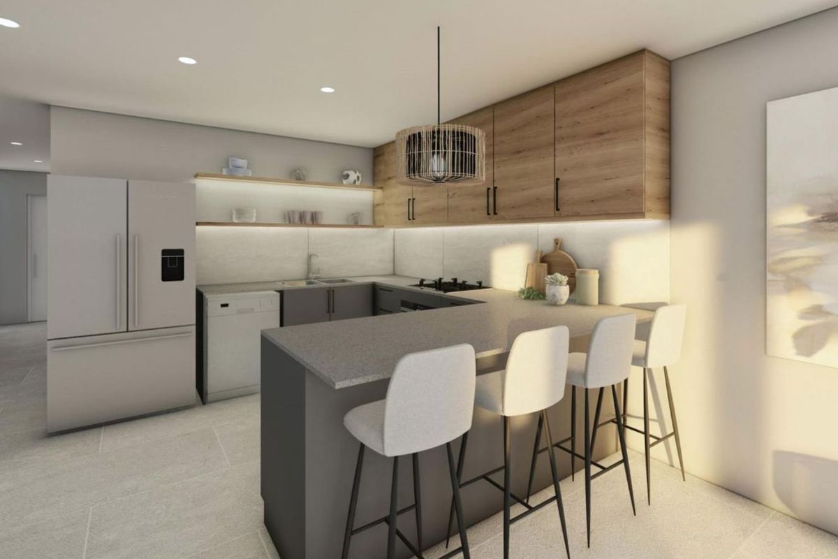 Modern kitchen featuring wood-tone cabinetry, stone countertops, a breakfast bar, and integrated lighting, creating a sleek and functional culinary space.