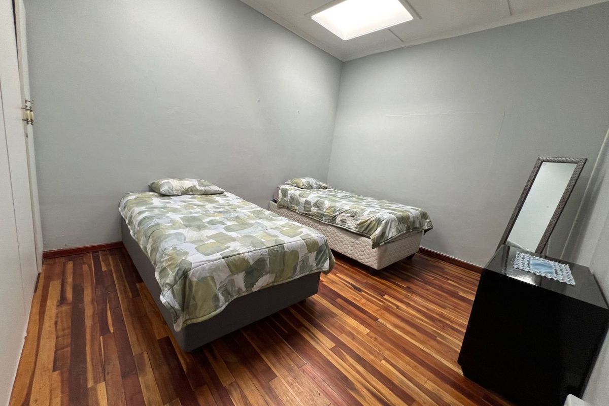 A bedroom featuring polished hardwood flooring, neutral wall finishes, and a recessed ceiling light fixture.