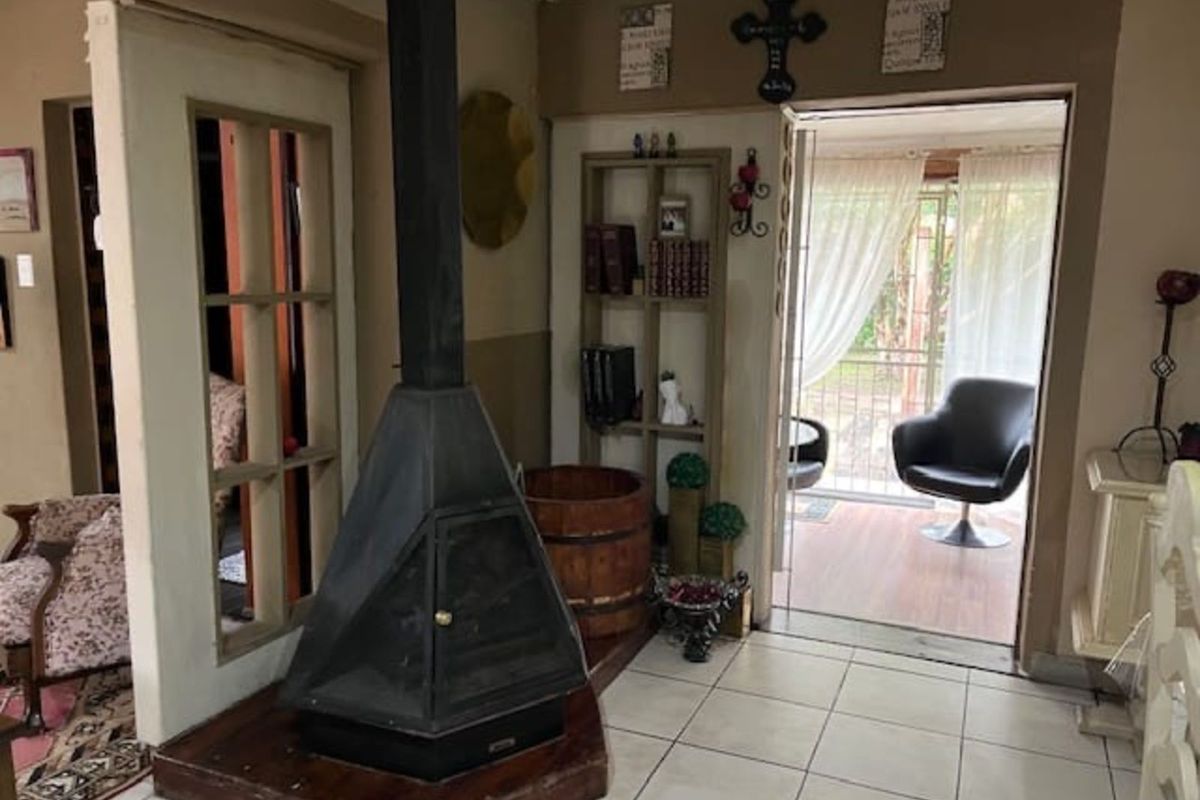 Living area featuring a central freestanding fireplace, tiled flooring, and direct access to an adjoining patio space.