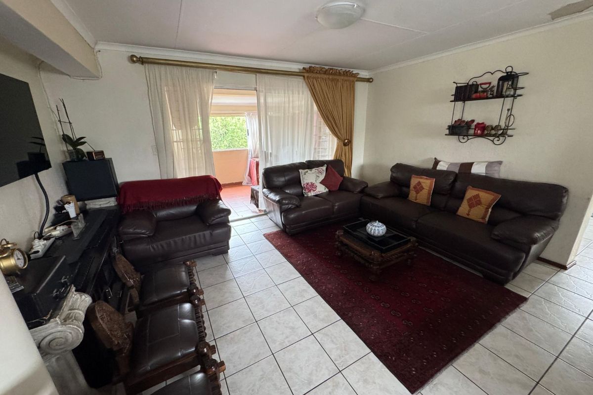 Spacious living room featuring tiled flooring and sliding glass doors that provide direct access to an outdoor patio area.