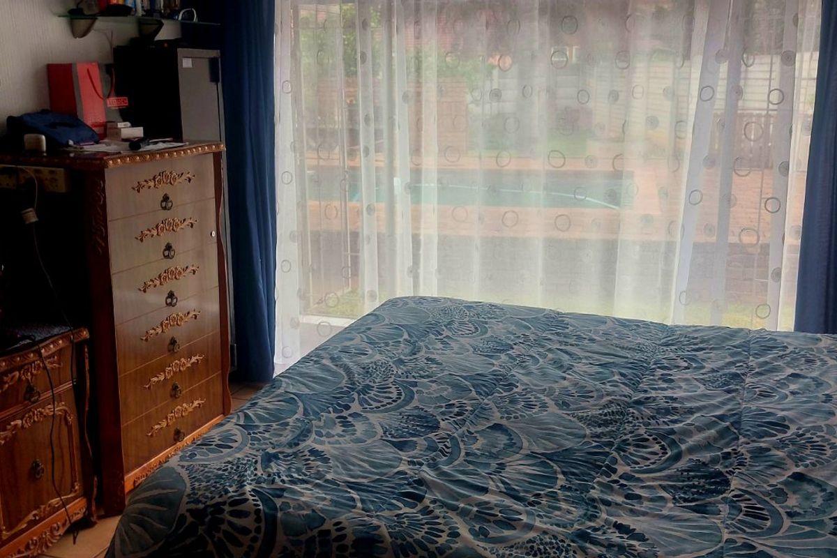 A bedroom featuring large sliding glass doors that provide direct access to the outdoor pool area.