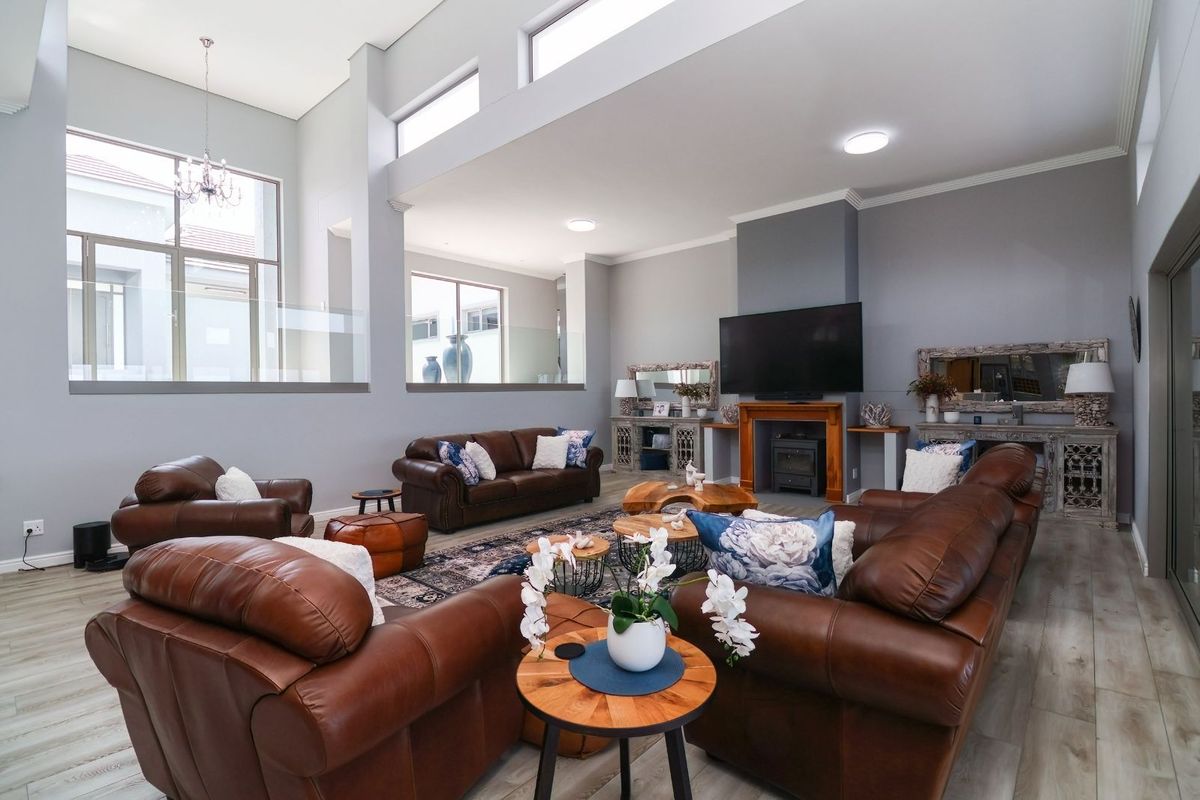 Spacious living room featuring high ceilings, clerestory windows, and a built-in fireplace, creating a bright and airy atmosphere with modern finishes.
