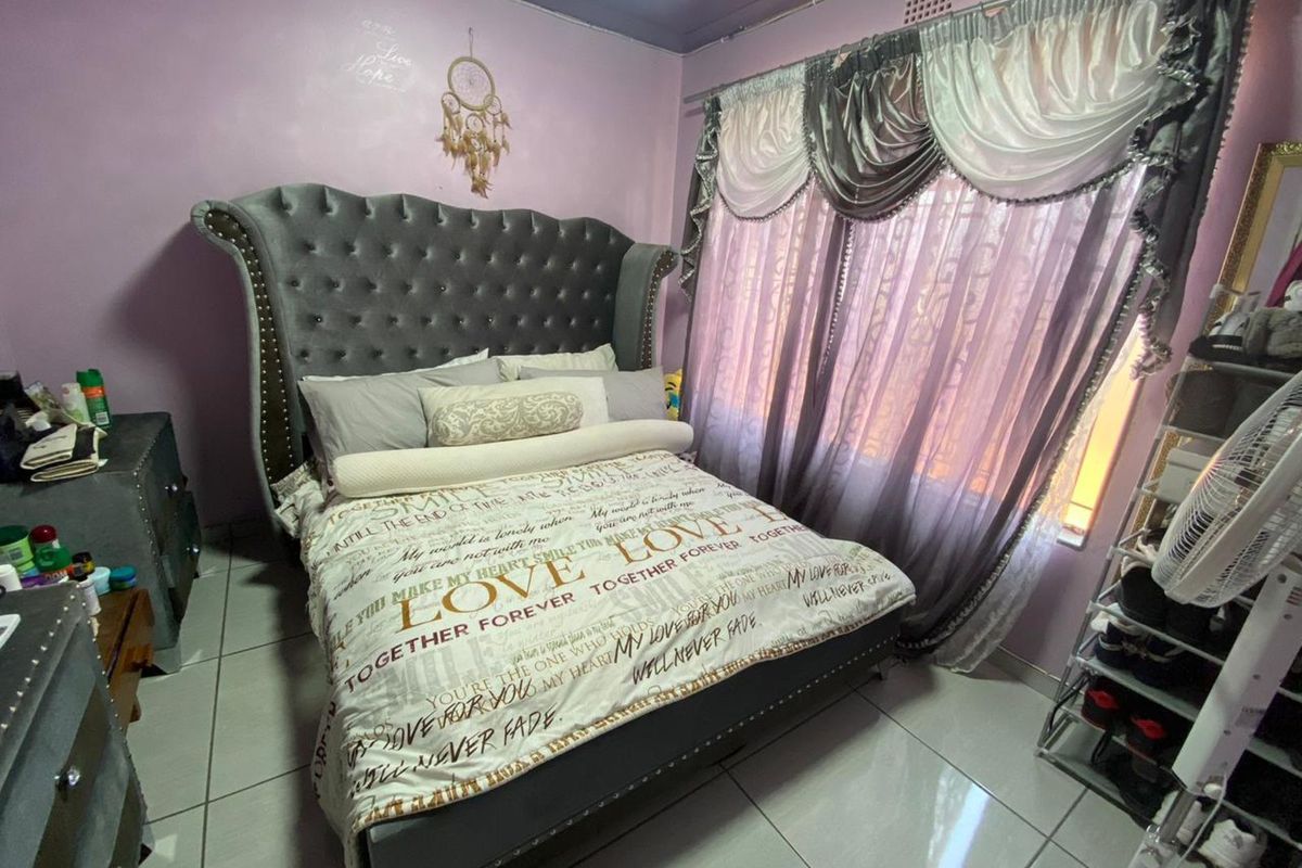 A bedroom featuring tiled flooring and a window with curtain tracks.