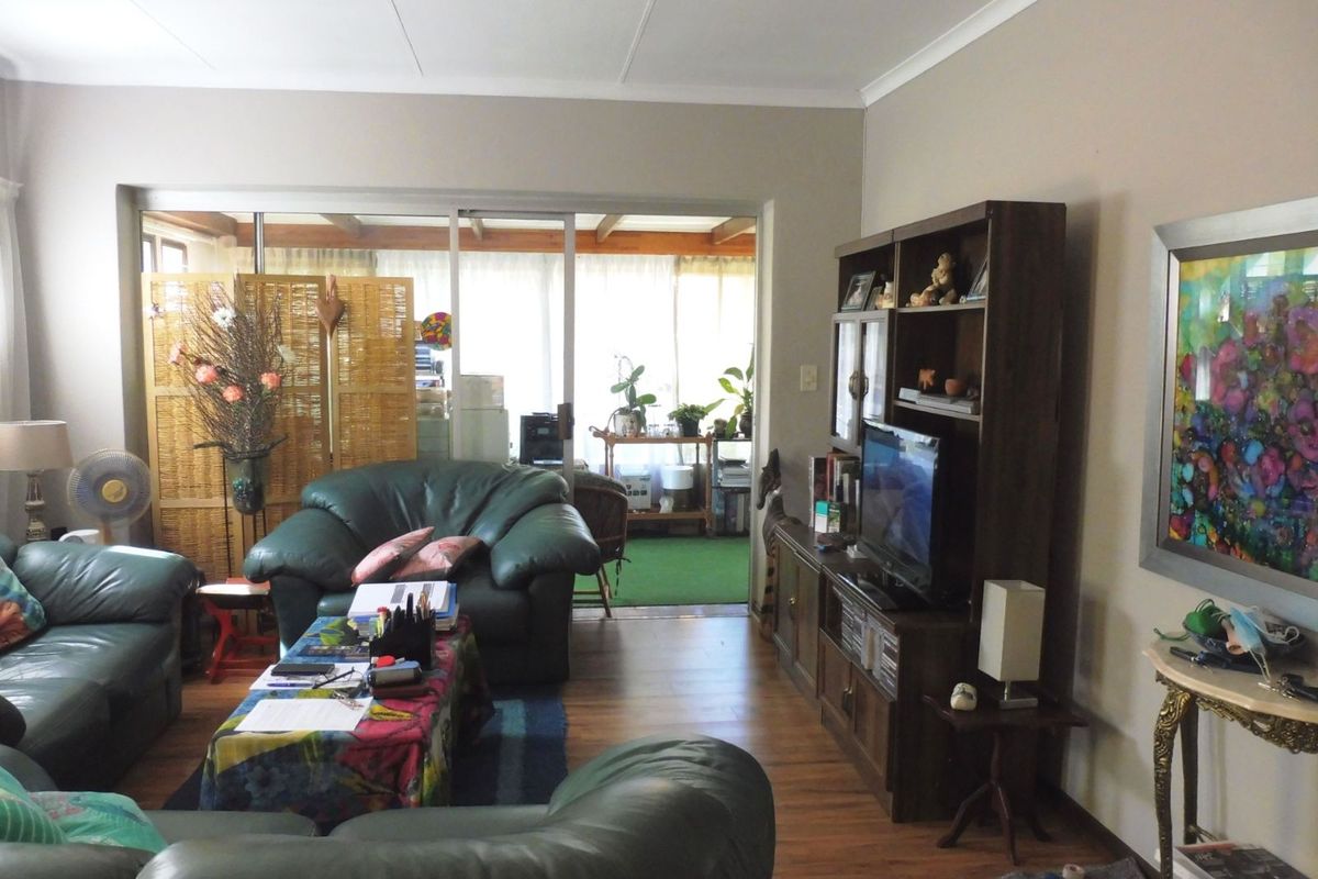 A living room featuring laminate flooring and sliding glass doors that open onto an adjacent patio area.