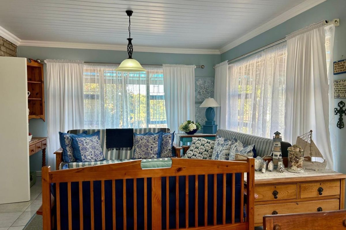 A cozy living room featuring a tongue-and-groove ceiling, tiled flooring, and large windows that allow for ample natural light.