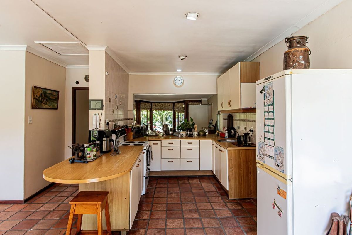 A functional kitchen featuring wooden cabinetry, a breakfast bar, tiled flooring, and a built-in stove, offering a practical layout for daily meal preparation.