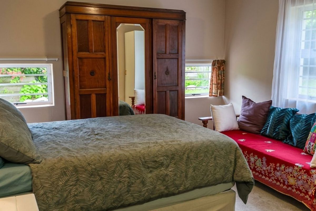 A bedroom featuring multiple windows providing natural light and a neutral wall finish.