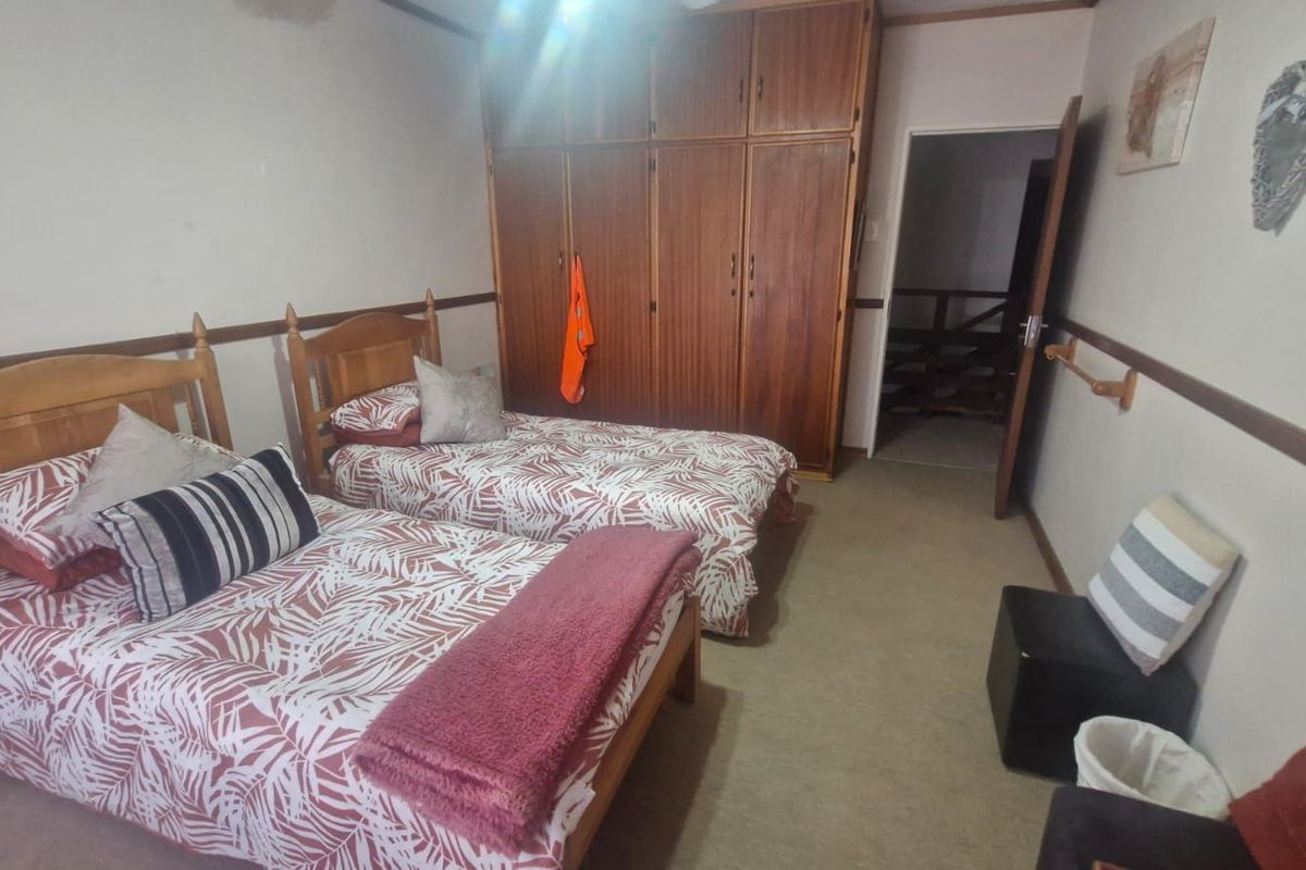 A bedroom featuring built-in wooden cupboards and carpeted flooring.