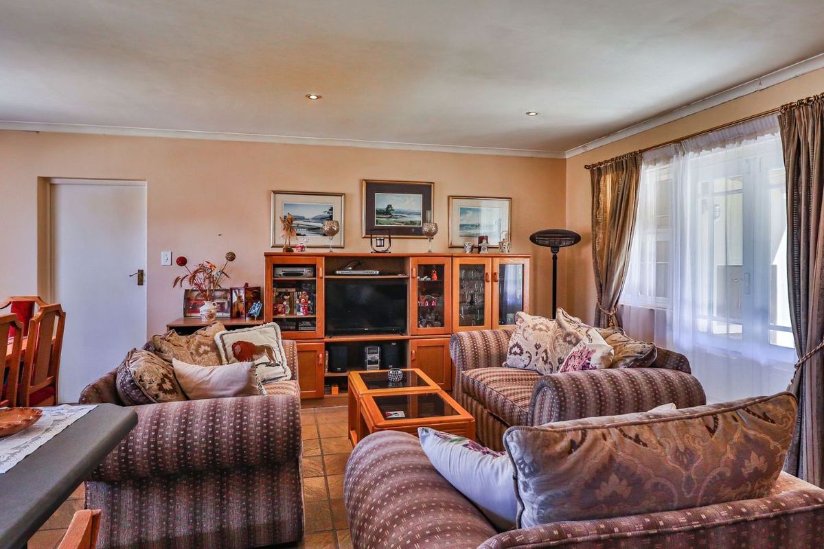 A comfortable living room featuring tiled flooring, recessed downlighting, and coved ceilings, providing a functional and well-lit space for relaxation.