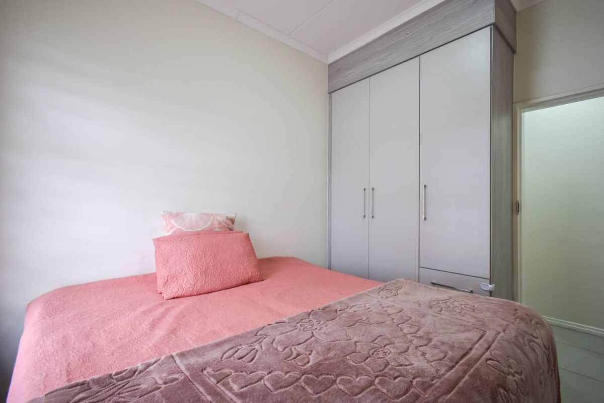 A well-maintained bedroom featuring built-in cabinetry with integrated storage and neutral finishes.