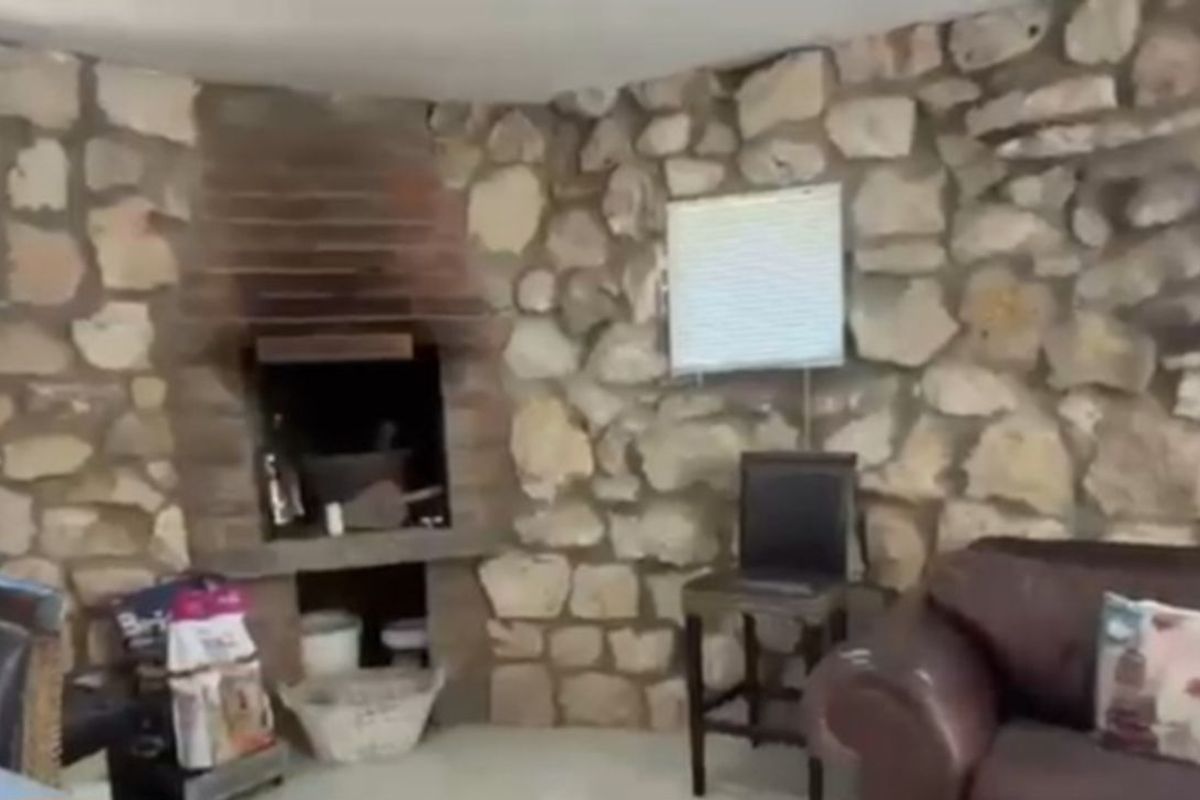 Rustic living area featuring distinctive natural stone walls and a built-in brick fireplace, creating a warm and characterful atmosphere.