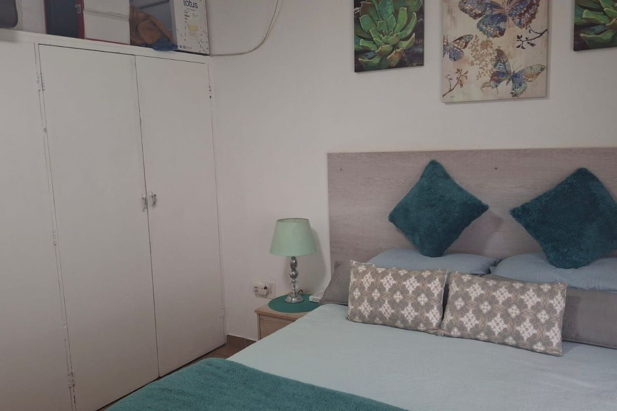 A functional bedroom featuring built-in wardrobe storage and a neutral layout, providing a comfortable and practical living space.