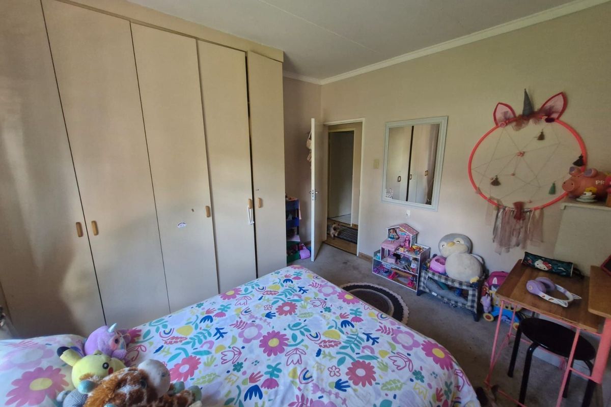A bedroom featuring built-in floor-to-ceiling cabinetry and a doorway leading to an adjacent space.