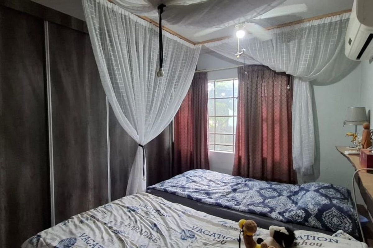 A bedroom featuring built-in floor-to-ceiling wardrobes, a wall-mounted air conditioning unit, and a ceiling fan.