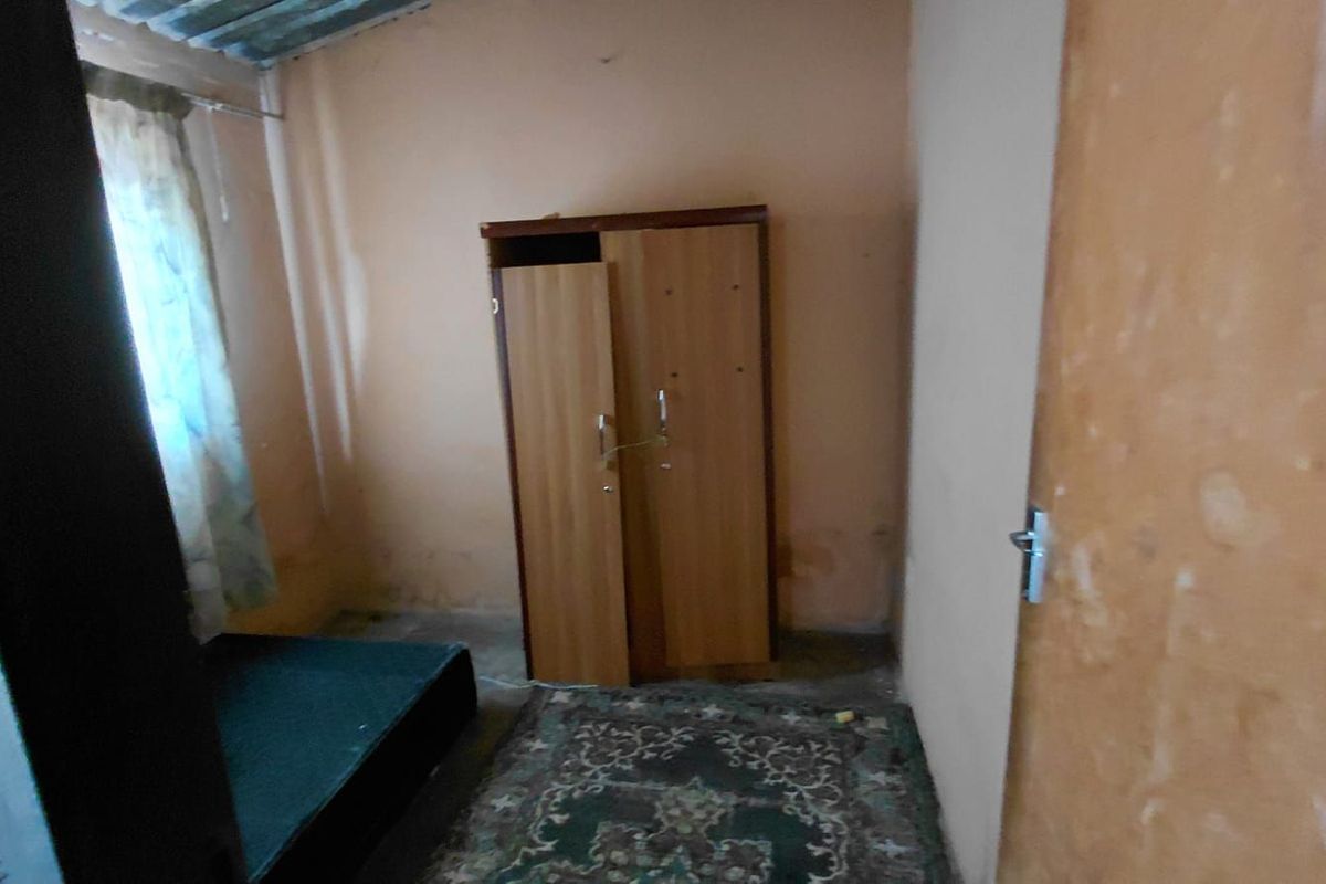 A small bedroom featuring basic finishes, including painted walls and a window, requiring cosmetic updates to improve its overall condition and appeal.