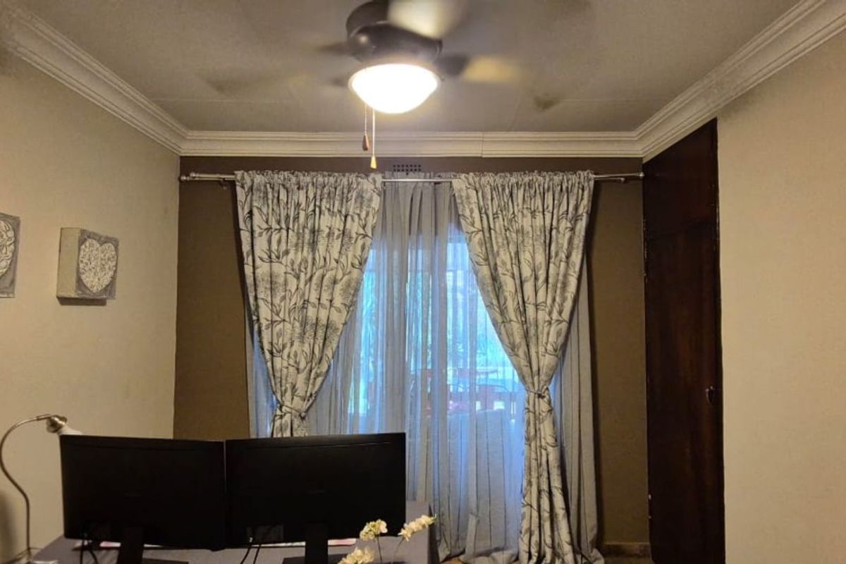 A bedroom featuring crown molding, a ceiling fan, and a built-in closet, with access to an outdoor area through sliding glass doors.