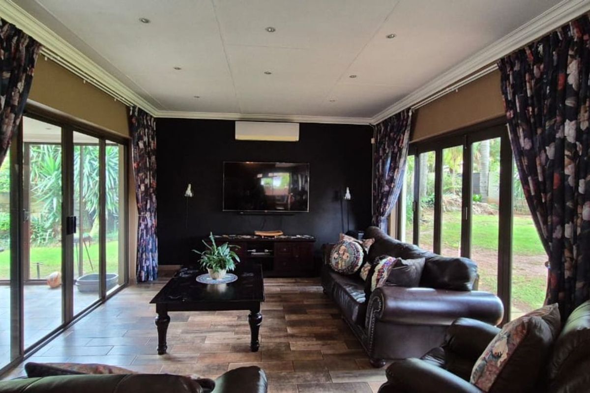 Spacious living room featuring large sliding glass doors that provide abundant natural light and direct access to the garden area.