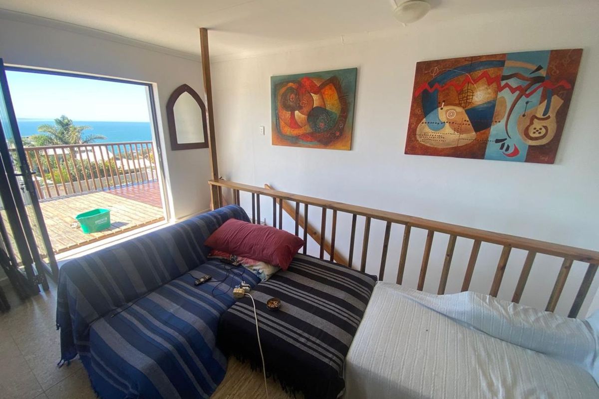 Living area featuring a timber balustrade and direct access to an outdoor balcony with scenic ocean views.