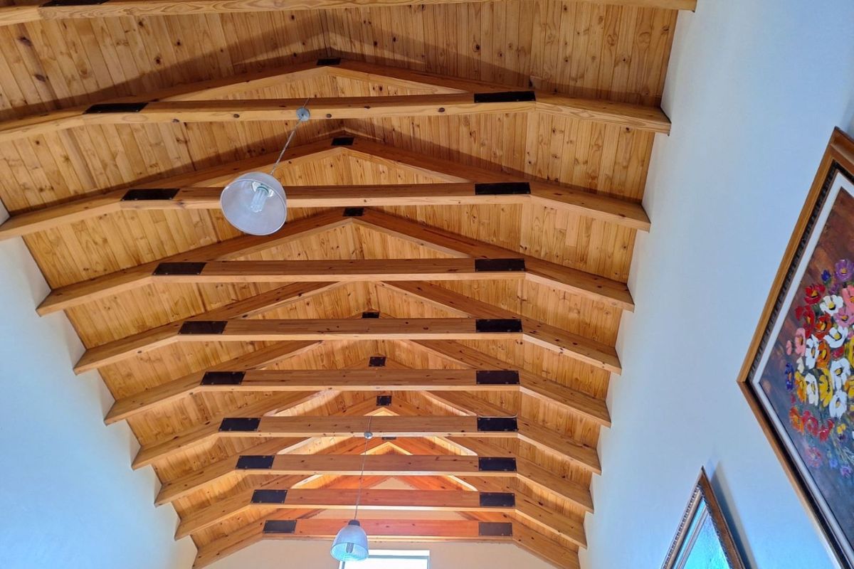 A high-ceilinged interior space featuring exposed timber rafters and tongue-and-groove wood paneling, creating a rustic and spacious architectural aesthetic.