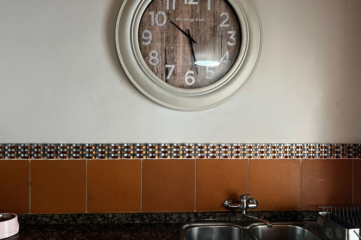 A kitchen sink area featuring a double stainless steel basin, granite countertop, and decorative tiled backsplash.