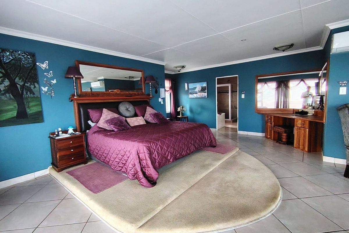 Spacious bedroom featuring tiled flooring, built-in wooden vanity, and direct access to an en-suite bathroom.