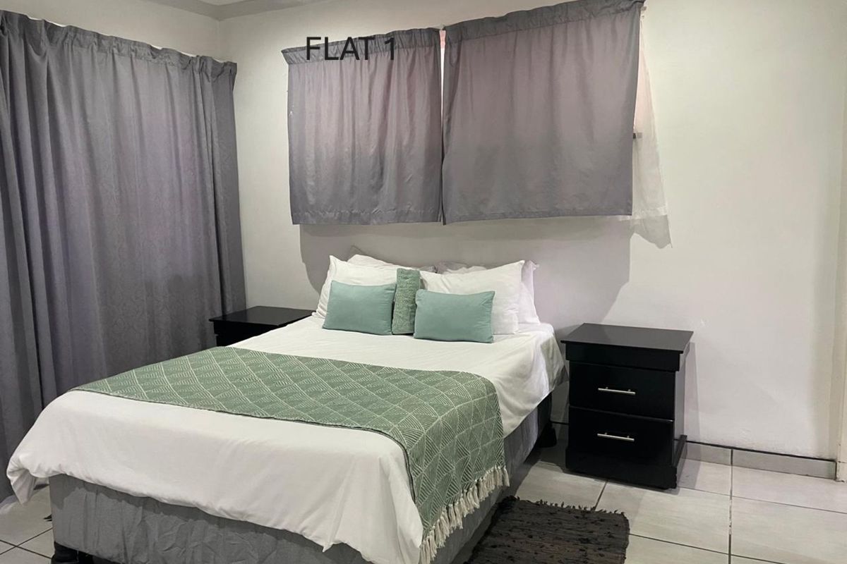 A bedroom featuring tiled flooring and neutral wall finishes, providing a functional and comfortable sleeping space.