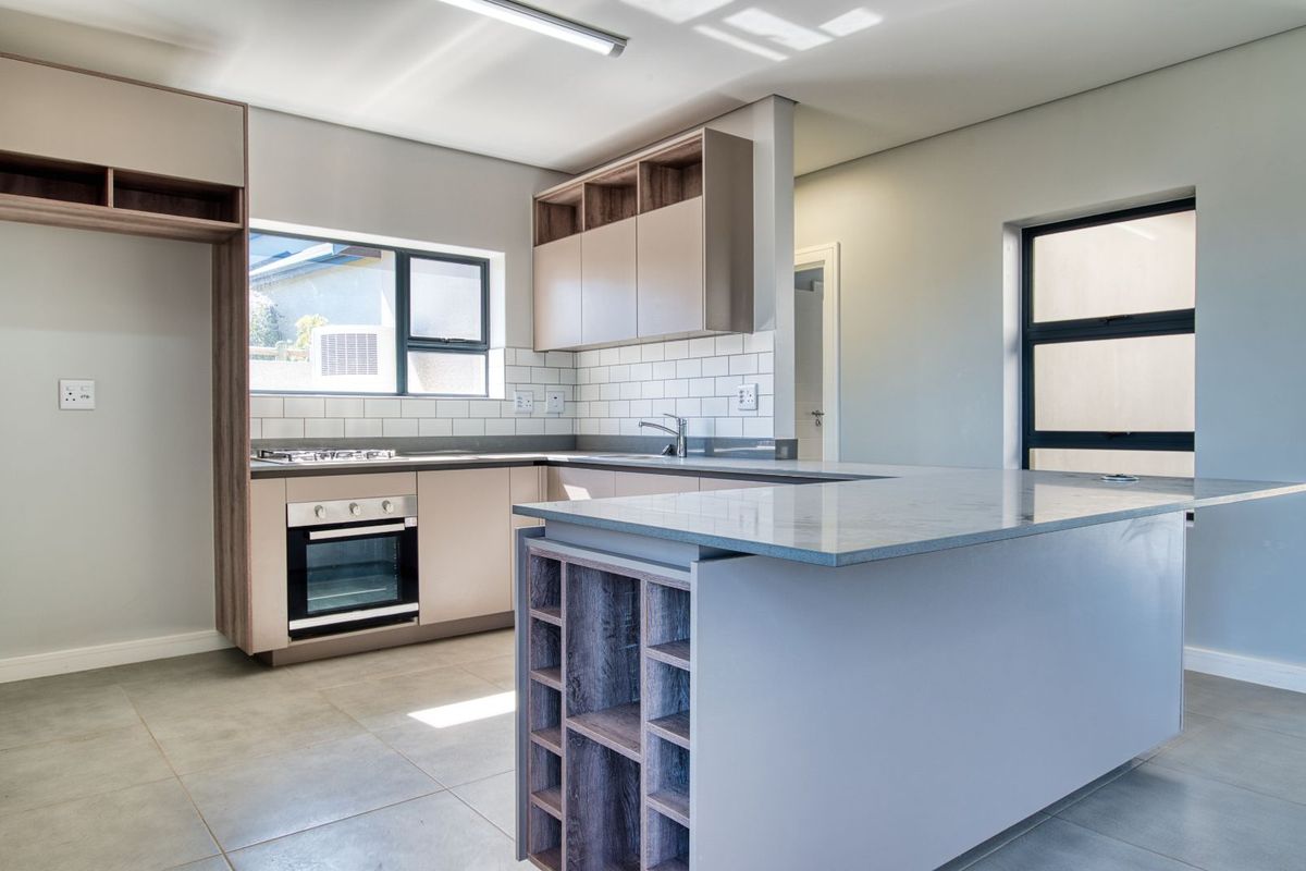 Modern kitchen featuring a breakfast island, built-in oven, gas hob, subway tile backsplash, and ample cabinetry with a neutral color palette.