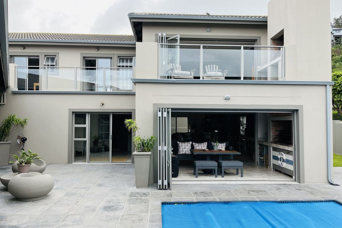 Rear view of the property featuring a paved patio, swimming pool with cover, and a covered outdoor entertainment area with built-in braai.