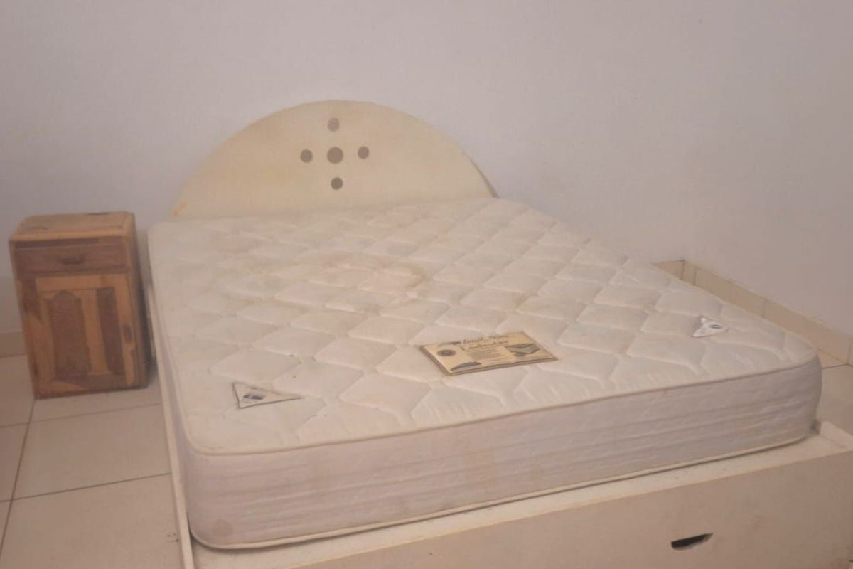 A bedroom featuring tiled flooring and a built-in bed frame with integrated storage.