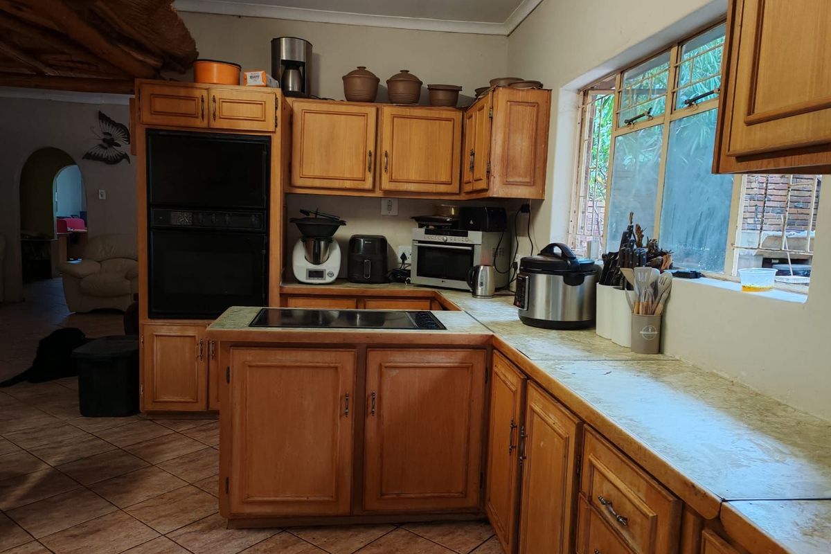 A functional kitchen featuring traditional wooden cabinetry, a built-in oven, and a ceramic hob, offering a classic layout with ample storage space.
