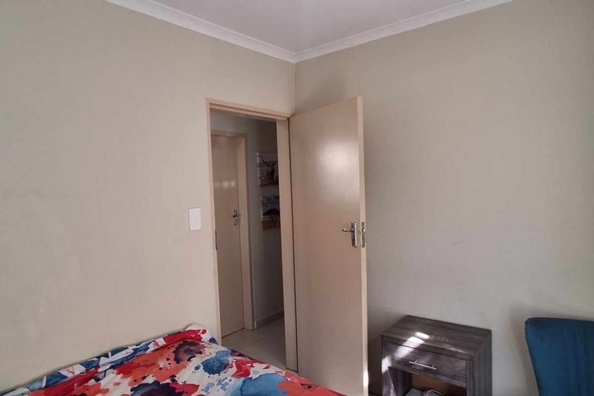 A standard bedroom featuring neutral wall paint, coving, and an internal door leading to a hallway.