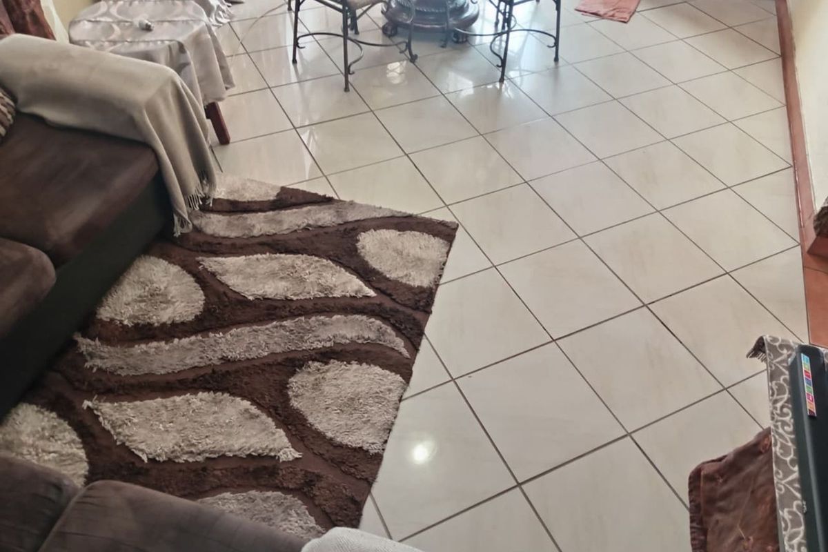 A living area featuring light-colored ceramic floor tiles laid in a diagonal pattern.