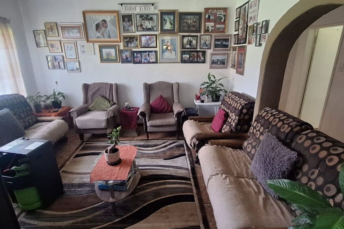 A comfortable living room area featuring an arched entryway and neutral wall finishes, providing a functional space for relaxation.