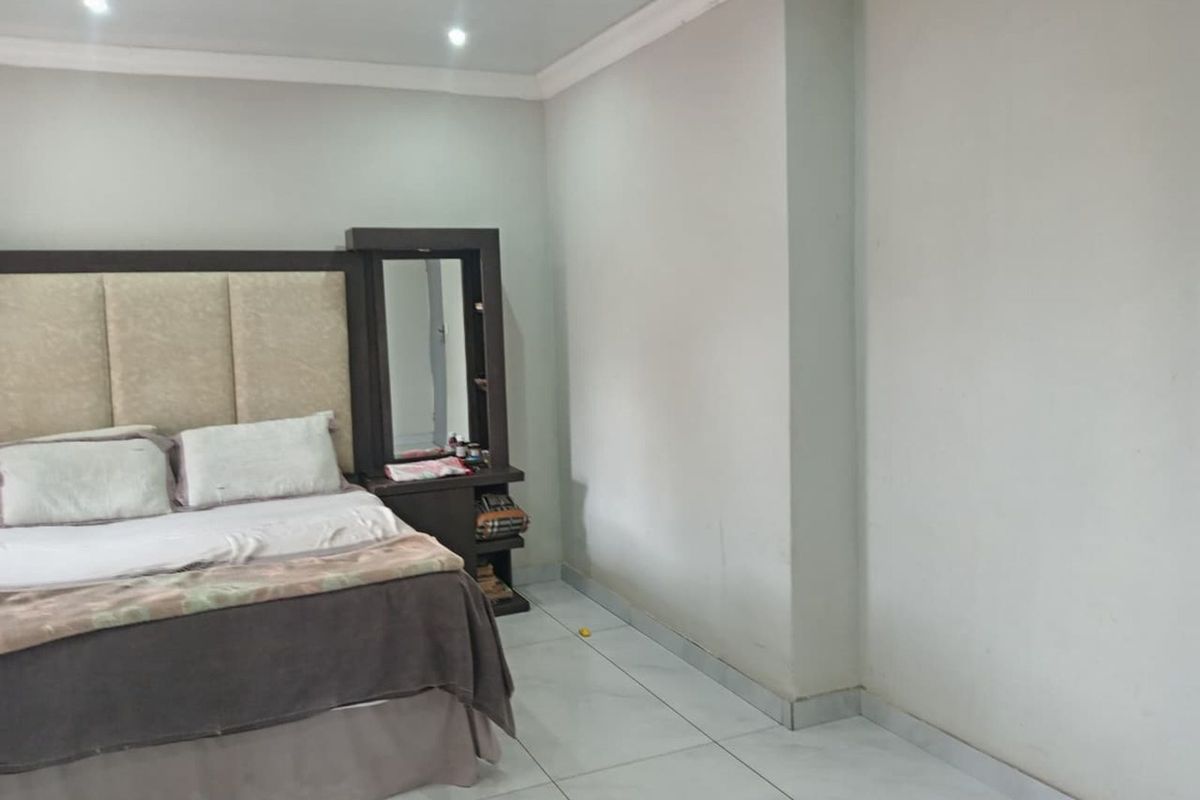 A bedroom featuring tiled flooring, recessed ceiling lighting, and crown molding, providing a neutral foundation for personal styling.