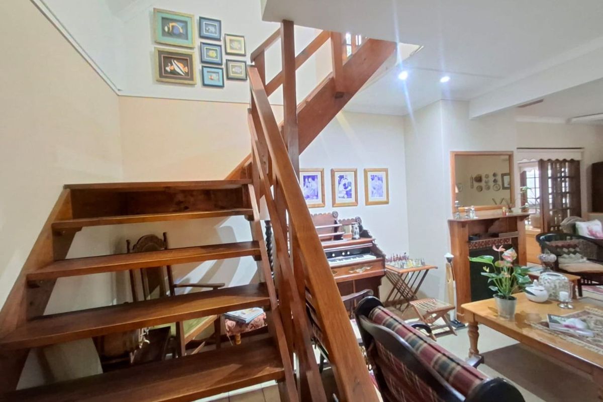 A living area featuring a wooden staircase with open treads and a built-in fireplace, creating a warm and traditional atmosphere.