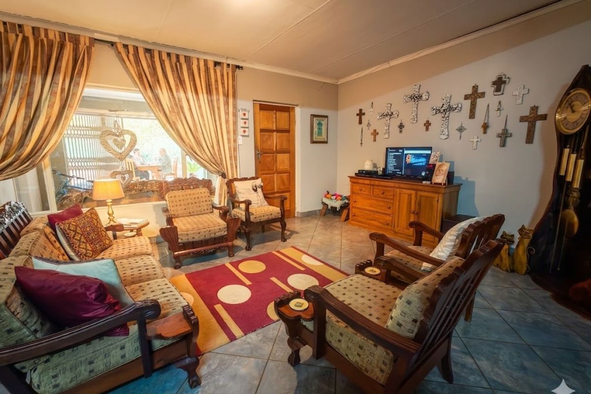 A traditional living room featuring tiled flooring, a wooden door, and large windows with curtains, providing a comfortable and functional living space.
