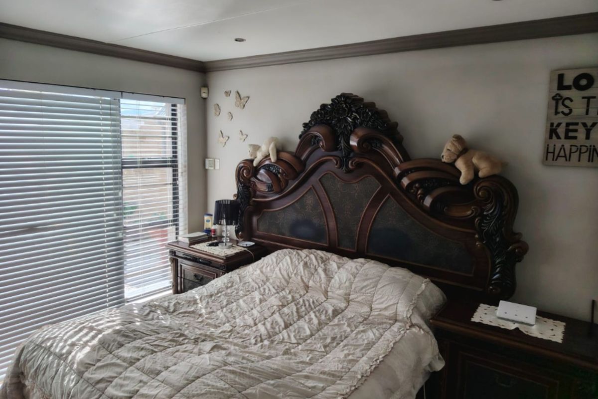 A bedroom featuring recessed ceiling lighting, crown molding, and large windows fitted with horizontal blinds.