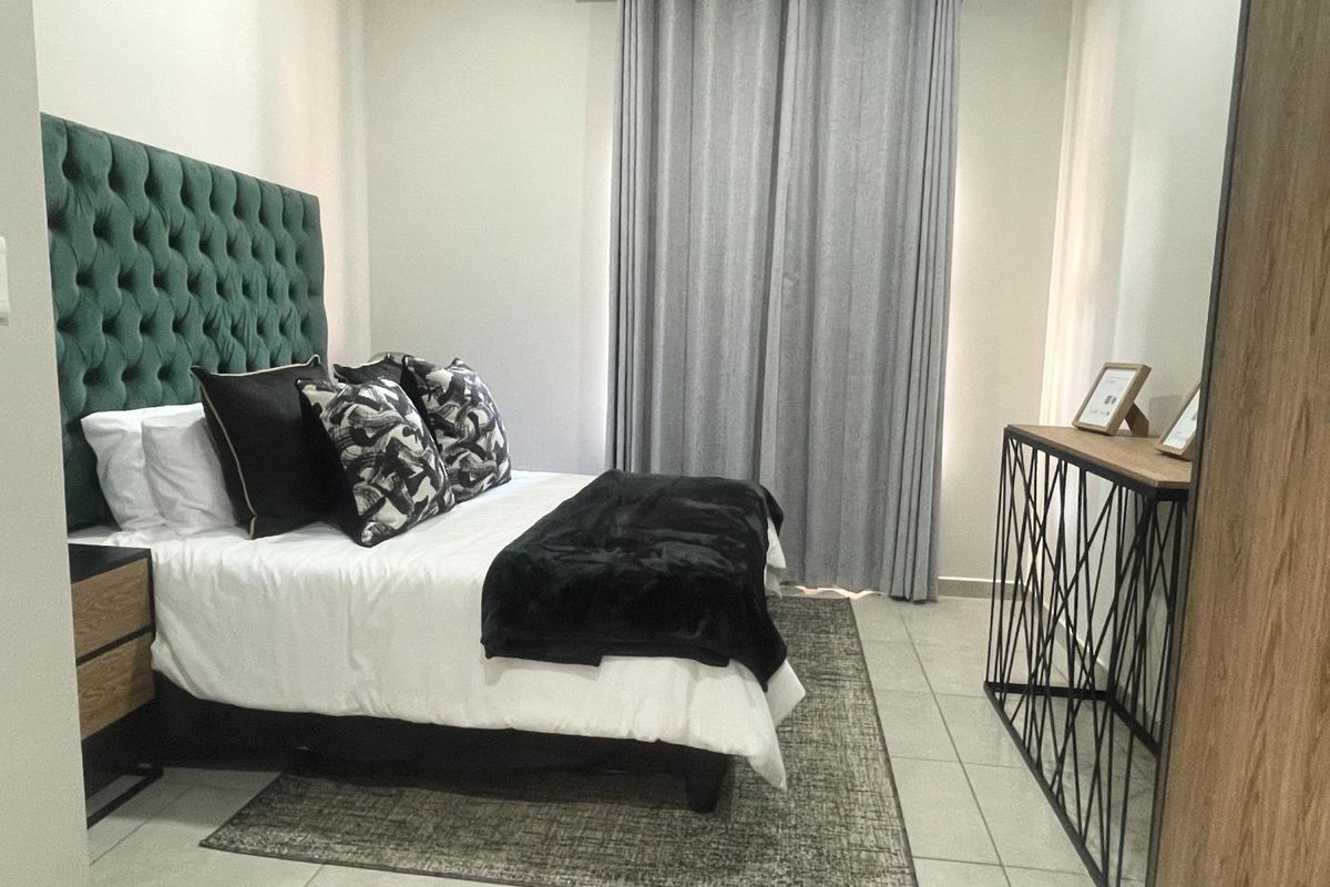 A well-maintained bedroom featuring neutral tiled flooring, clean wall finishes, and a curtain rod installation.