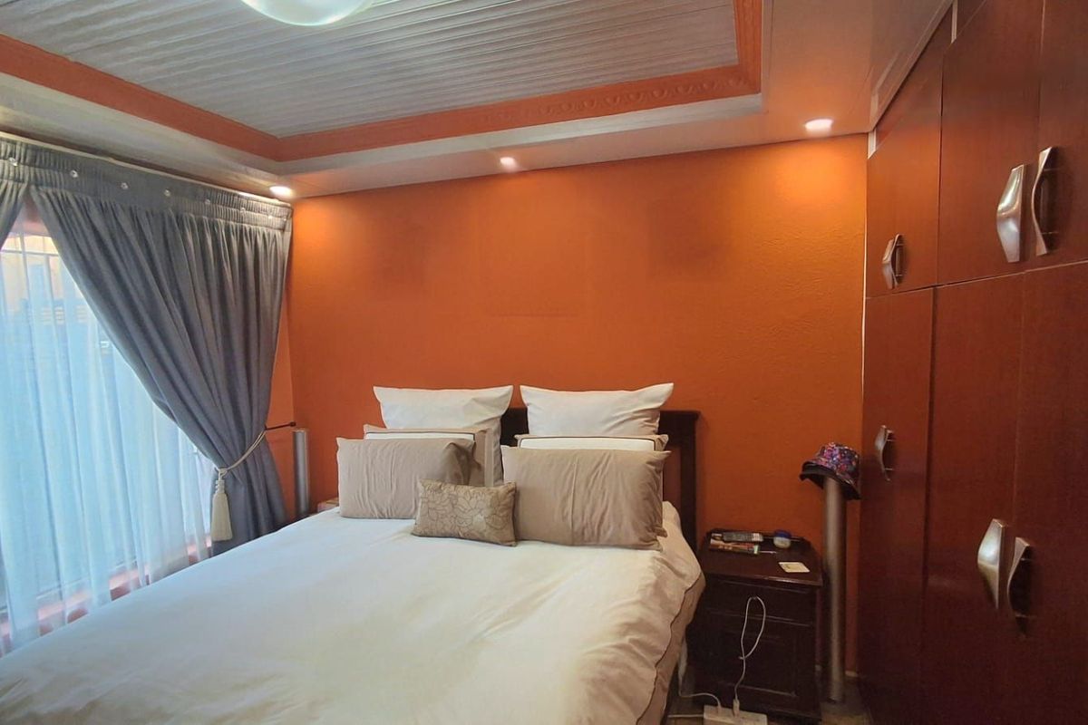 A bedroom featuring built-in wooden cabinetry and recessed ceiling lighting.